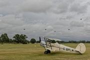 Parachutists descend behind Stampe 7024
